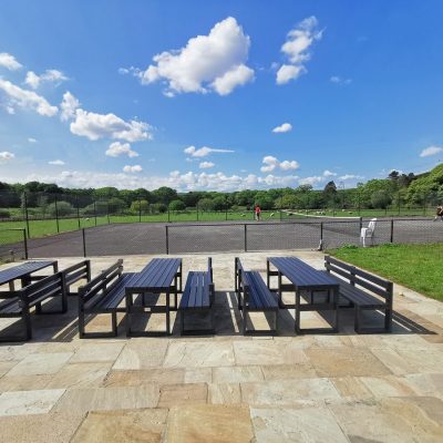 Outdoor dining at Plas Cilybebyll overlooking the tennis court and parkland